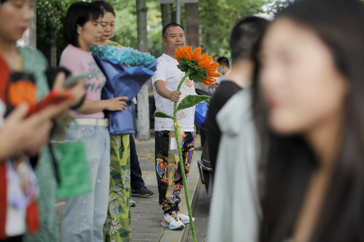 01，6月8日下午，在西安高级中学考点，不少考生家长和家人手捧花束在考场外迎接考生，仪式感满满。当日，全国部分地区2024年高考结束。（梁萌摄）
