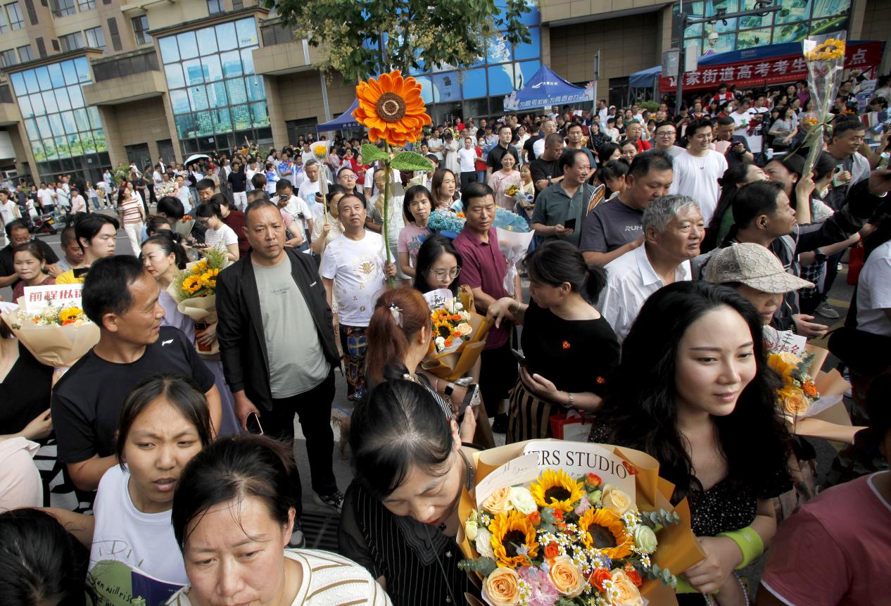 06，6月8日下午，在西安高级中学考点，不少考生家长和家人手捧花束在考场外迎接考生，仪式感满满。当日，全国部分地区2024年高考结束。（梁萌摄）