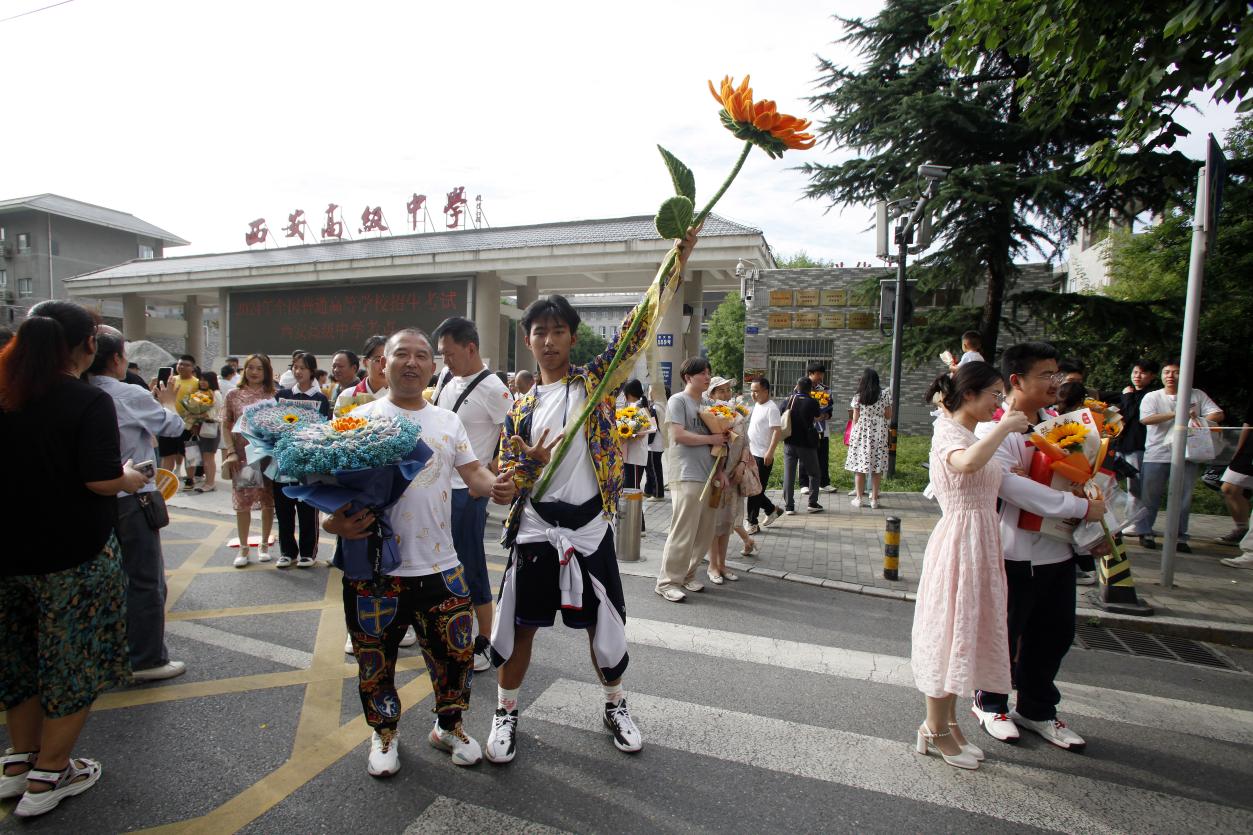 24，6月8日下午，在西安高级中学考点，一位考生手举“向日葵”与家人霸气留影。当日，全国部分地区2024年高考结束。（梁萌摄）