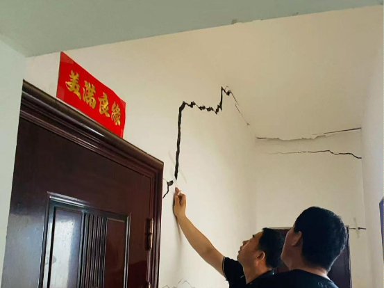 高主任在天阁村查看危房情况