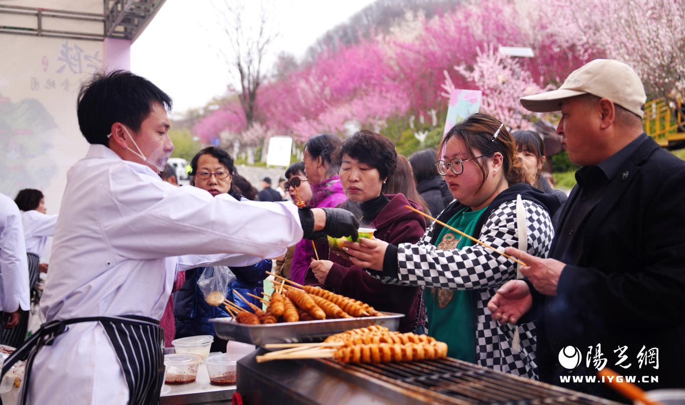 子午梅苑小吃点位游客正品尝美食（杨稳 摄）